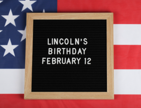 American flag with the words "Lincoln's Birthday February 12" on a sign
